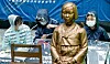 University students tie themselves to a statue symbolizing ’comfort women“ victims in front of the old Japanese Embassy in central Seoul Wednesday and stage a sit-in protest after the organizers of weekly rallies to resolve the issue of Japanese wartime sexual slavery lost their usual turf to a conservative group. [NEWS1]