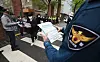 Police hand out notices to students alerting them of potential drug crimes in front of a high school in Songpa District, southern Seoul on Tuesday. [YONHAP]