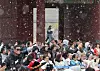 Tourists watch a gatekeeper appointing ceremony at Gyeongbok Palace in central Seoul on March 30 as light snow fell over the capital amid a cold spell ahead of spring flower festivals. [YONHAP]