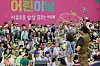 President Yoon Suk Yeol, center, and hundreds of kids and their parents watch a bubble magic show at an event to mark Children’s Day at the Blue House, the former presidential compound, in central Seoul, on Sunday. [PRESIDENTIAL OFFICE]