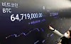 A display at Upbit, a cryptocurrency exchange in Gangnam District, southern Seoul, shows the price of bitcoin surpassing 64.7 million won ($58,322) Monday morning. [YONHAP]