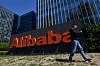 A man walks past an Alibaba sign outside the company's office in Beijing on April 13, 2021. [AFP]