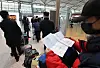 A traveler to Shenzhen, China, prepares two papers proving that they have had a negative polymerase chain reaction (PCR) coronavirus test result at a check-in counter in Incheon International Airport on Wednesday. According to the National Emergency Management Agency and Chinese Embassy, all travelers who wish to go to China from Korea must submit their negative result from a PCR test taken within 48 hours of their departures starting Wednesday. [YONHAP]