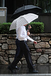 Workers move in the rain near offices in Seocho District, southern Seoul, on Tuesday, following the smallest increase in hires at large companies recorded. [YONHAP]