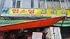 A storefront sign reads ″black goat soup,″ though traces of the old sign ″bosintang″ are still visible. [JOONGANG ILBO]