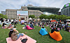 People sit and read books at the Seoul Outdoor Library installed in Seoul Plaza, central Seoul. [YONHAP]