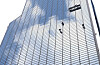 Workers clean the glass windows of a building reflecting the clouds and the blue sky in Gangnam District, southern Seoul, on Aug. 18. [YONHAP]