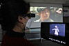 An official demonstrates a digital device that offers descriptive video and subtitle services in sync with movies at a press event held Thursday in Yeouido, western Seoul. The event was held to highlight the various technology that can help people with visual and hearing impairments watch movies. [YONHAP]