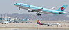 A Korean Air plane takes off at Incheon International Airport with an Asiana Airlines plane taxing behind. [YONHAP]