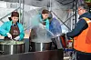 Volunteers including Hana Bank executives and employees, alongside members of the Myeong-dong Merchants Association, help out at the Myeong-dong Bab House, a soup kitchen located in Myeongdong, central Seoul. [HANA BANK]