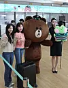 Air Seoul employees pose for a photo with Brown and lenini, characters from IPX, formerly known as Line Friends, next to the Air Seoul check-in counter at Incheon International Terminal on Monday. Air Seoul and IPX are joining forces for a co-marketing strategy, according to Air Seoul. [YONHAP]
