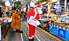 A man dressed in a Santa Claus costume disinfects an outdoor market in Busan on Thursday as Christmas draws near. [SONG BONG-GEUN]