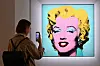 A woman takes a photo of Andy Warhol's 'Shot Sage Blue Marilyn' during Christie's 20th and 21st Century Art press preview at Christie's New York in New York City. An iconic portrait of Marilyn Monroe by American pop art visionary Andy Warhol went under the hammer for a record $195 million on Monday at Christie's, becoming the most expensive 20th century artwork ever sold at public auction. [AFP/YONHAP]