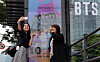 Fans of BTS pose for photos in front of the HYBE headquarters building in Yongsan District, central Seoul. [NEWS1]