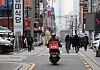 A Yogiyo food delivery passes by restaurants in Gangnam District, southern Seoul during lunch hour last December. [YONHAP]