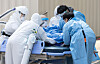 Paramedics and medical staff transfer a Covid-19 patient at Seoul Medical Center in Jungnang District, eastern Seoul, on Tuesday. [NEWS1]
