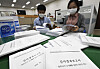 National Assembly workers look at copies of a report submitted by the Board of Audit and Inspection on the government's decision to shut down the Wolsong I nuclear reactor. [YONHAP]