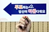 An election official holds up a voting stamp in front of a polling station in Yeongdeungpo District, western Seoul, on the eve of Korea's general election on Tuesday. [YONHAP]
