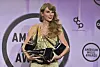 Taylor Swift poses in the press room with the awards for artist of the year, favorite music video for ″All Too Well: The Short Film,″ favorite female pop artist, favorite pop album for ″Red (Taylor's Version),″ favorite female country artist and favorite country album for ″Red (Taylor's Version)″ at the American Music Awards on Sunday, at the Microsoft Theater in Los Angeles. [AP/YONHAP]