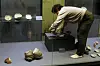 An employee at the Buan Celadon Museum clears an exhibition space of debris after the earthquake on Wednesday. [NEWS1]