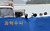 Police take photographs of the overturned vehicle belonging to the family of 10-year-old schoolgirl Cho Yoo-na behind a blue forensic investigation screen in Wando, South Jeolla on Wednesday. [YONHAP]