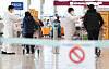 Health officials place stickers on travelers from abroad at the Incheon International Airport Terminal 1 Thursday afternoon amid concerns over the spread of coronavirus variants from overseas. [YONHAP]