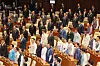 Ruling Democratic Party (DP) lawmakers don hanbok, or traditional Korean clothing, while rival People Power Party (PPP) lawmakers wear black mourning attire as they sing the national anthem during a plenary session at the National Assembly in Yeouido, western Seoul, on Sept. 1 as the parliament kicks off its 100-day regular session. National Assembly Speaker Woo Won-shik encouraged lawmakers to wear hanbok for the opening session in a sign of unity, but the PPP chose to wear mourning attire in protest. [YONHAP]