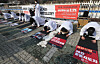 Representatives of a federation of Pilates and fitness center owners take a deep bow as they urge the government Tuesday in front of the National Assembly in Yeouido, western Seoul, to allow them to reopen their businesses. [YONHAP]
