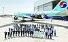 Korean Air cabin crew and staffs pose in front of its aircraft wrapped with Busan expo logo and K-pop girl group Black Pink. [KOREAN AIR]