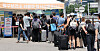 People with luggage wait to get tested for Covid-19 at a testing center erected outside Seoul Station in central Seoul on Sunday. [YONHAP]