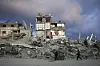 A man pushes a cart past a house that remains partly standing, but with sheets serving as makeshift walls, in an area largely destroyed by the Israeli army's air and ground offensive in Gaza City, Gaza Strip, Wednesday, Feb. 5. [AP/YONHAP]