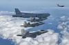 A U.S. B-52 Stratofortress bomber flies alongside three F-22 Raptor stealth bombers and a C-17 Globemaster transport aircraft in the distance during a training mission near the Korean Peninsula on Dec. 20. [DEFENSE MINISTRY]