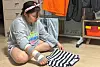 A 11-year-old family caregiver, Koo Hye-bin, folds her laundry with her injured hand. [LEE BO-RAM]