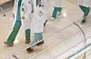 Doctors wearing their medical gowns walk inside a general hospital in downtown Seoul on Monday. [YONHAP]