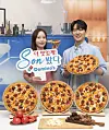 Models hold up Domino Pizza's upcoming menu item, K-Rib & Cheese Pizza, set to be released on Friday. The Pizza features ″Sonny cube cheese,″ inspired by Son Heungmin, the brand's ambassador, and his signature pose. [DOMINOS PIZZA]