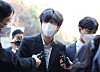 Lawyer Nam Wook, a key figure in the Daejang-dong development corruption scandal, is surrounded by reporters as he walks to his trial at the Seoul Central District Court in Seocho District, southern Seoul on Monday. [YONHAP]