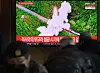 Travelers at Seoul Station watch the news about a North Korean missile launch on Sunday morning. [YONHAP]