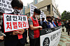 Civic group members hold a vigil Tuesday to mourn a security guard who took his own life after being subject to alleged physical and verbal abuse by an apartment resident. [YONHAP]