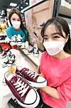 Models pose with sneakers at Homeplus’ Gangseo branch in western Seoul on Tuesday. Celebrating its 24th anniversary, Homeplus is selling private brand, or PB, products such as sneakers and socks at sharply discounted prices until the end of the month. [HOMEPLUS]