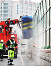 Janitors clean noise barriers on an overpass in Suwon, Gyeonggi, on Thursday. [YONHAP]