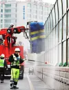 Janitors clean noise barriers on an overpass in Suwon, Gyeonggi, on Thursday. [YONHAP]