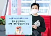 An employee at Philip Morris Korea holds a banner promoting a new parental leave policy at the companay's office in Yeouido, western Seoul. [PHILIP MORRIS KOREA]