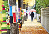 A person holding an umbrella walks by trees wearing colorful cloth covers on a street in Gwangmyeong, Gyeonggi, as it starts to get chilly on Monday. [YONHAP]