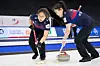 Team Korea's Kim Seon-yeong (left) and Kim Cho-hee sweep their brushes in the path of a moving stone against Scotland at the Curling World Championship in Calgary, Canada on Sunday. [WCF]