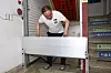 A shop owner at a traditional market in Seoul on Sunday places a steel panel that would prevent waters from getting into the basement during heavy rain. [YONHAP]