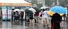 Umbrellas in hand, people line up in front of a Covid-19 testing center in front of Seoul Station in Jung District, central Seoul on Sunday afternoon. [NEWS1]
