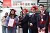 Eastar Jet CEO Cho Joong-seok, fourth from left, and company officials pose for a photo with a passenger who won a promotional event at Gimpo International Airport on Sunday. [YONHAP]