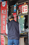 A man purchases a lottery ticket from a lottery store in downtown Seoul on Thursday. [YONHAP]