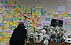 A woman writes a letter of condolence to a young subway worker outside a public restroom at Sindang Station in Jung District, central Seoul, on Sunday, four days after the worker was stabbed to death by her former colleague. [YONHAP]