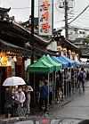 Customers wait in front of a samgyetang restaurant in Seoul on Tuesday, this year's Chobok — the first day of the hottest season according to the traditional Korean calendar. Koreans eat samgyetang, chicken and ginseng soup with sticky rice, to replenish their strength during periods of energy-sapping hot weather. [YONHAP]